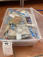 Plastic bin filled with multiple sealed bags containing vintage baseball cards from 1986 to 1991.