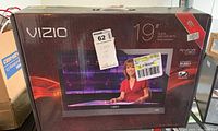 Box for the Vizio 19-inch LED LCD HDTV showing brand, series, and model number E190VA, and display of a news anchor on screen in promotional image on box.