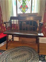 Front view of the wooden side bench showing straight backrest and armrests