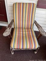 Maple wooden outdoor chair with striped cushions on seat and backrest, showing significant paint chipping and wear.