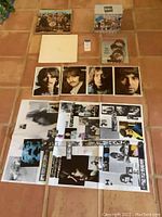 Overview of all items laid out on floor: two albums, prints, posters, magazine, VHS box