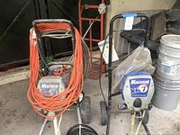 Front view of both Graco Magnum sprayers on wheeled carts with hoses and cords