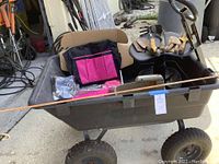 Overview photo of the gardening wagon containing apron, gloves, hand tools, and seed spreader, showing items together and wagon layout