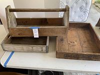 Wooden boxes on a table showing Pepsi crate, wooden box with handle, and General Radio Co tray