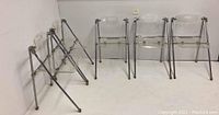 Five folding chairs arranged against white wall, showing overall set layout