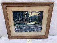 Full view of the framed watercolor painting showing the deer standing in a stream surrounded by trees.