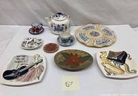Full lot arrangement showing all items including teapot, espresso cups, and decorative plates with various artistic designs
