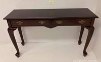 Front view of vintage Bombay sofa table in mahogany with two drawers and brass handles.
