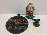 Santa doorstop along with bell and fire insurance plaque grouped together on white background