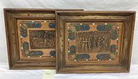 Pair of framed vintage pressed art panels showing neoclassical mythical scenes and ornate border with colorful floral accents.
