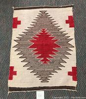 Full view of vintage Southwestern wool rug displaying central geometric diamond pattern with red, brown and beige colors.