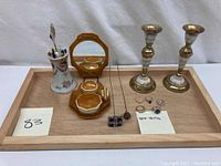 Full lot setup showing Victorian hat pins in ceramic holder, vanity mirror set, sterling silver rings, and candlesticks on a wooden tray (not included).