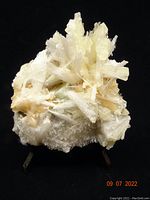 Full view of the mineral specimen showing clusters of pale yellow stilbite and white sclocite needles with some cubic apophyllite crystals.