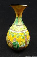 Full frontal view of pear-shaped vase showing figural enamel decoration on yellow ground