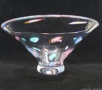Side view of a large clear glass bowl with colorful embedded millefiori dots, showing flared rim and rounded base.