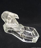 Full view of the clear and frosted glass ashtray/trinket dish with polar bear figure on black background.