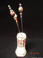 Porcelain Nippon hatpin holder with three decorative hatpins showing overall look and design