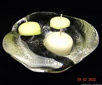 Clear glass 3-light tealight candle holder with textured surface resembling a melting glacier, holding three tealight candles.