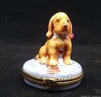 Front view showing golden retriever puppy on blue base and gold dog head clasp