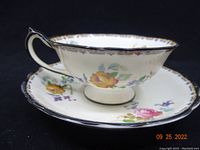 Photo showing the side profile of the Star Paragon tea cup placed on the matching saucer, highlighting the floral design and dark rim edge.