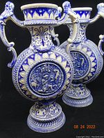 Pair of large blue and white salt glazed stoneware moon flask vases with handles and detailed relief scenes.