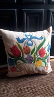 Front view showing hand painted floral basket design on fabric pillow.