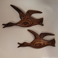 Two wooden geese wall hangings shown from a front angle on a neutral background.