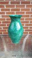 Full view of the handmade ceramic vase showing its mottled teal and turquoise glaze.
