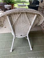 Photo of the underside of white wicker chair showing woven pattern and structural support