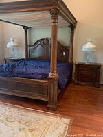 Two crystal lamps shown on nightstands flanking a canopy wooden bed, with brass and marble bases and unique fabric shades with fringe.