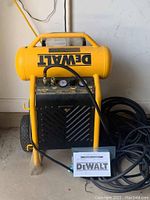 Front view of compressor showing tank, frame, gauge panel and hose