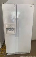 White Kenmore side-by-side refrigerator and freezer, front view showing water and ice dispenser on left door.