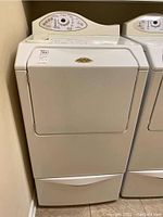 Front view of the Maytag Neptune washing machine and pedestal showing the door and storage drawer.