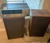 Front view of Sansui receiver seated between two Audio Acoustics speakers on carpet