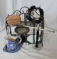 Collapsible metal shelf and all accompanying pottery and decor items arranged for display.