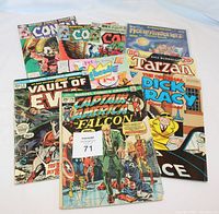 Photo showing nine assorted vintage comics including Conan, Vault of Evil, Captain America and Falcon, Dick Tracy, The Monsters, and Tarzan comics, laid out overlapping with visible wear.