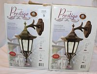 Two boxes of Prestige Collection outdoor lights shown side-by-side with detailed packaging images