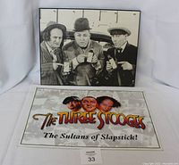 Black and white Three Stooges metal sign with the trio holding items.