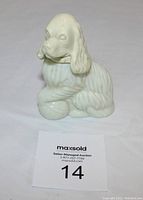 Front view of the vintage Avon dog patchwork cologne bottle showing the detailed dog figure in white ceramic.