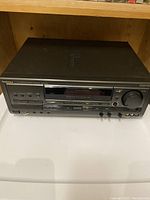 Full front view of the black Technics SA-EX700 stereo receiver showing power button, headphone and mic jacks, display screen, tuning and control buttons, and large volume knob.