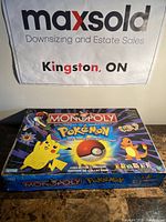 Front of the retail box showing Pokémon Monopoly Collector's Edition branding with Pikachu and Charmander images.