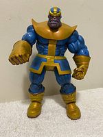 Front angle of the 2011 Marvel Thanos action figure approximately 8 inches tall showing full body in blue and gold outfit with detailed muscular design.