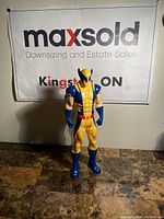 Full front view of Wolverine figure standing on a marble surface with MaxSold backdrop.