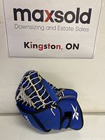 Front and side view of blue Reebok goalie glove showing white lacing and logo with black trim in good condition.