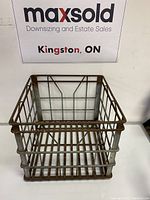 Front and top angled view of vintage metal milk crate showing metal grid construction and rust