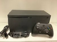 Front view of console, controller and cables arranged side by side