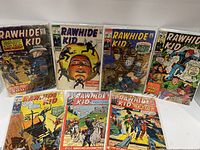 Front view showing eight Rawhide Kid comic books laid out for display, covers visible with western themes.