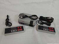 Top view of Mini NES system with two wired controllers and cables laid out on white surface.