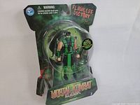 Full front view of the Mortal Kombat Classic Reptile figure in original unopened blister packaging showing character details and packaging art.