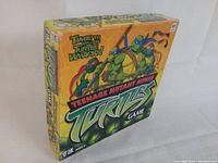 Front and side view of Teenage Mutant Ninja Turtles board game box showing colorful artwork and branding.